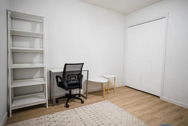a view of a workspace with furniture and a window