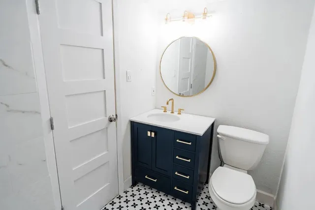a bathroom with a toilet a sink and a mirror