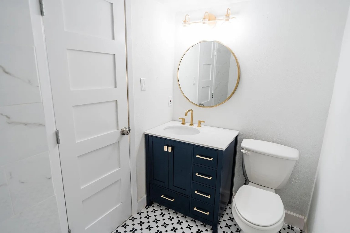 2600 Penny Lane, Unit 112 Austin, TX 78757 - Photo 14 of 20 a bathroom with a toilet a sink and a mirror