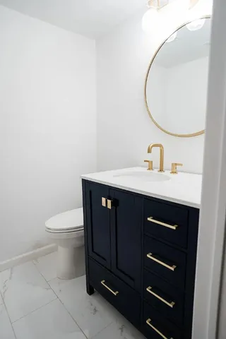 a bathroom with a sink a toilet and a mirror