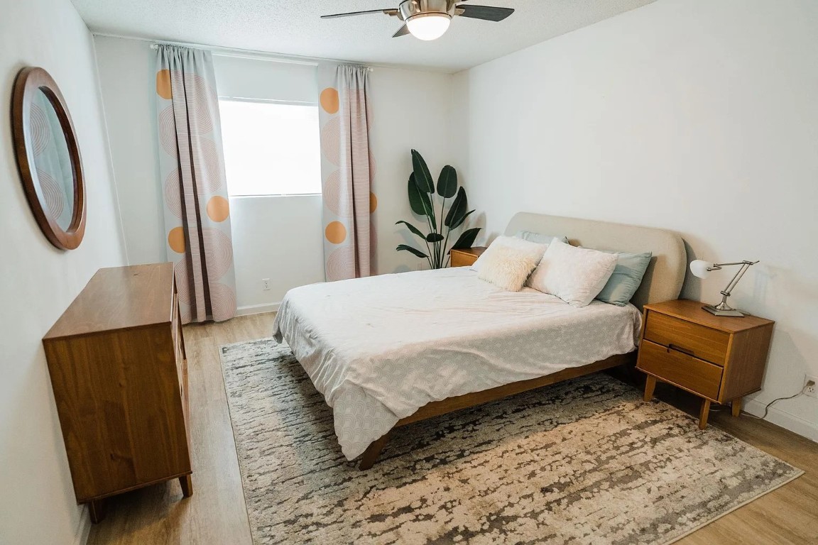 2600 Penny Lane, Unit 112 Austin, TX 78757 - Photo 8 of 20 a bedroom with a bed a couch and a potted plant