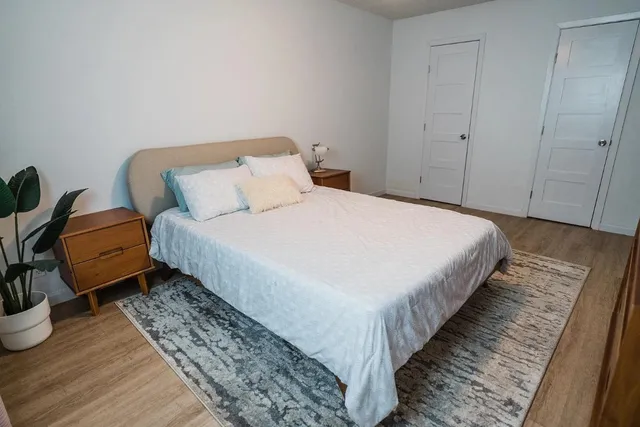 a bedroom with bed and wooden floor