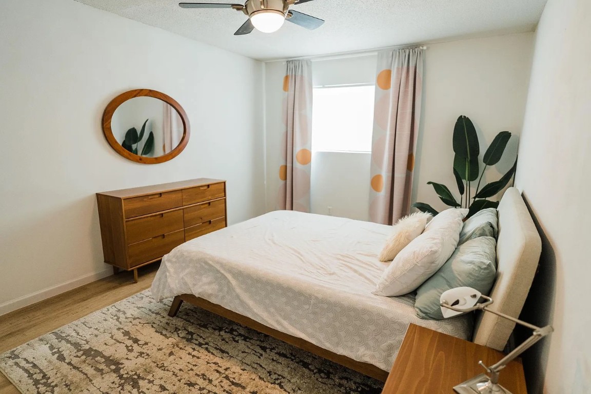 2600 Penny Lane, Unit 112 Austin, TX 78757 - Photo 10 of 20 a bedroom with a bed a mirror and lamp on desk