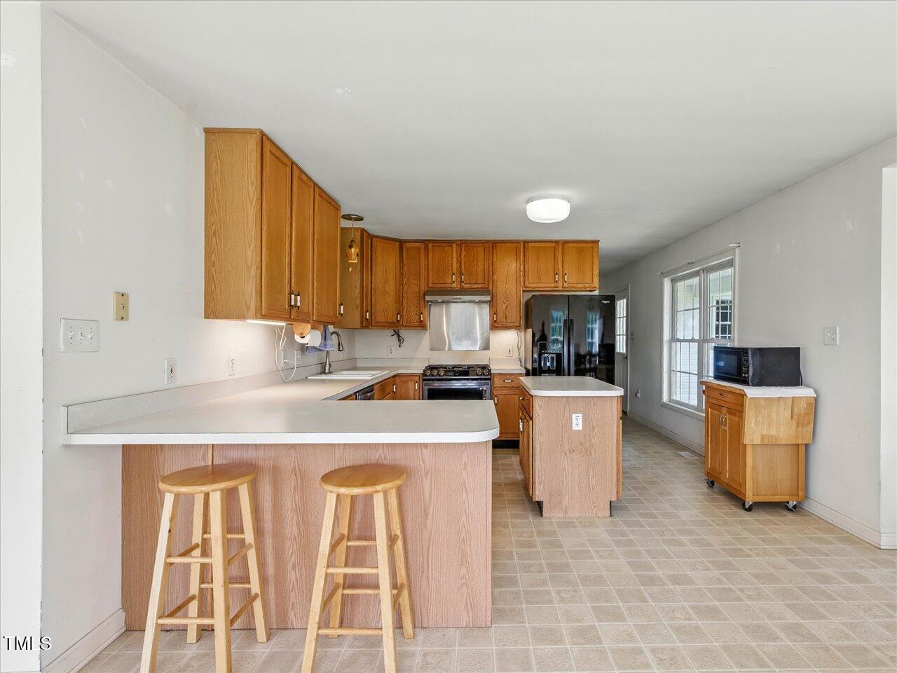 2892 Silk Hope Liberty Road Siler City, NC 27344 - Photo 15 of 74 a kitchen with a stove a sink a counter top space and cabinets