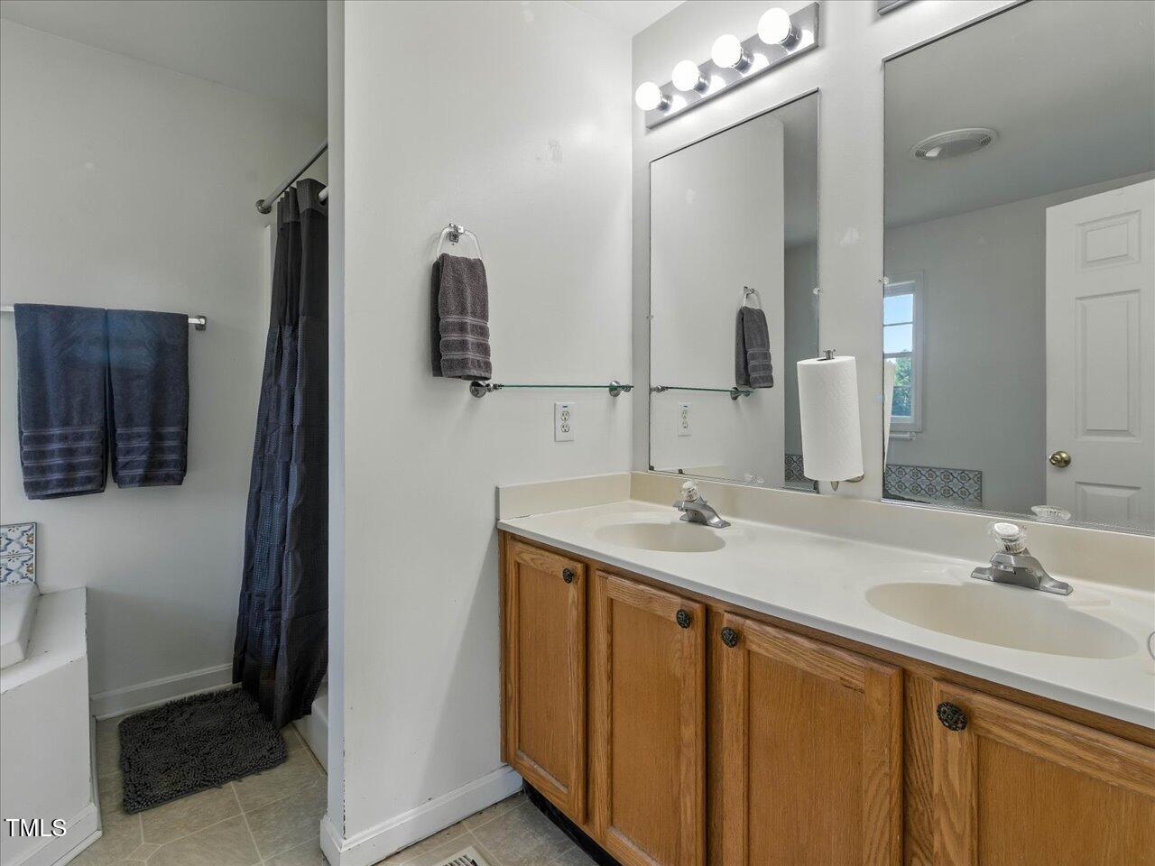 2892 Silk Hope Liberty Road Siler City, NC 27344 - Photo 24 of 74 a bathroom with a sink double vanity and a mirror