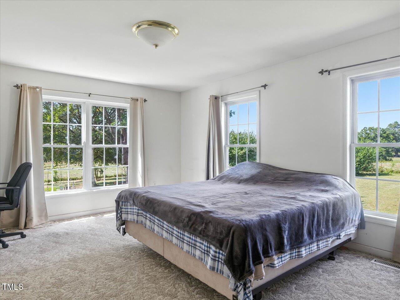2892 Silk Hope Liberty Road Siler City, NC 27344 - Photo 26 of 74 a bed sitting in a spacious bedroom next to a window