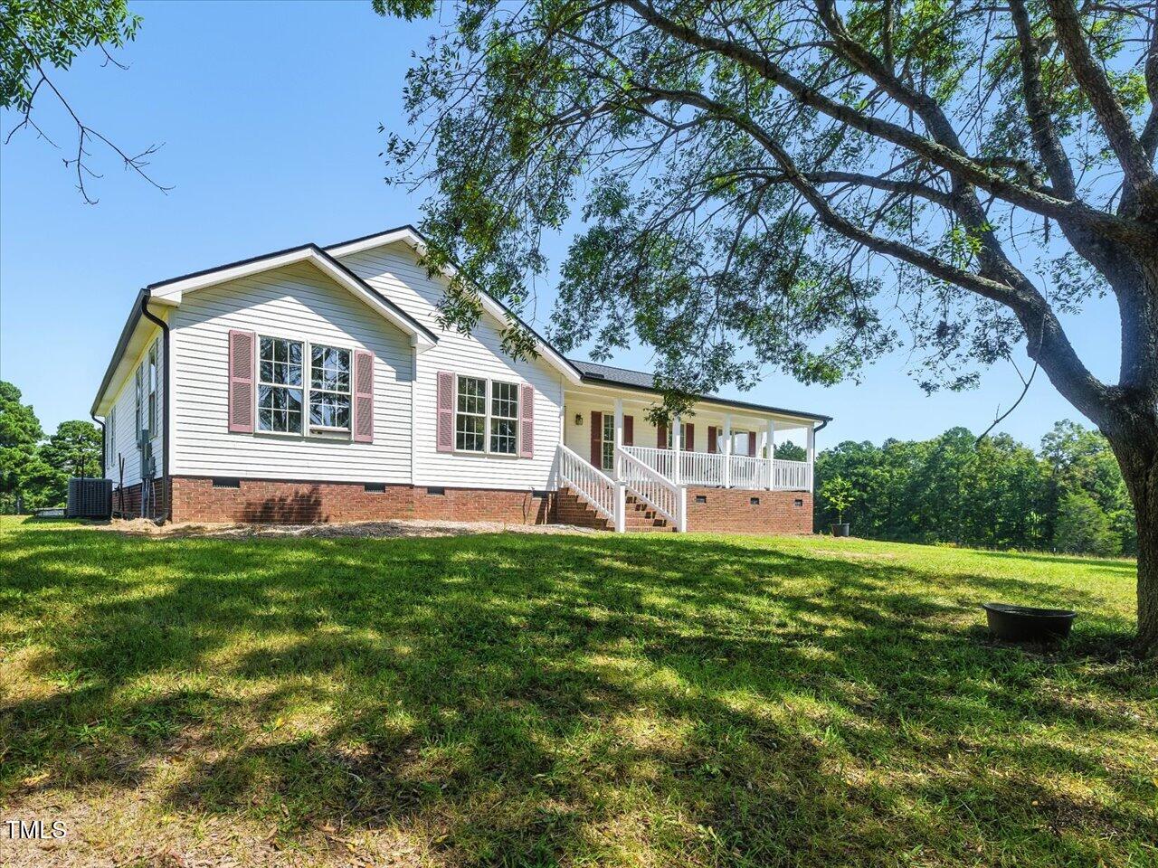 2892 Silk Hope Liberty Road Siler City, NC 27344 - Photo 4 of 74 a front view of a house with a garden