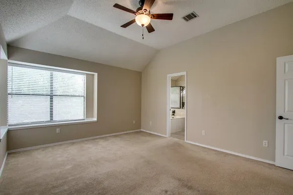 a view of an empty room and chandelier fan