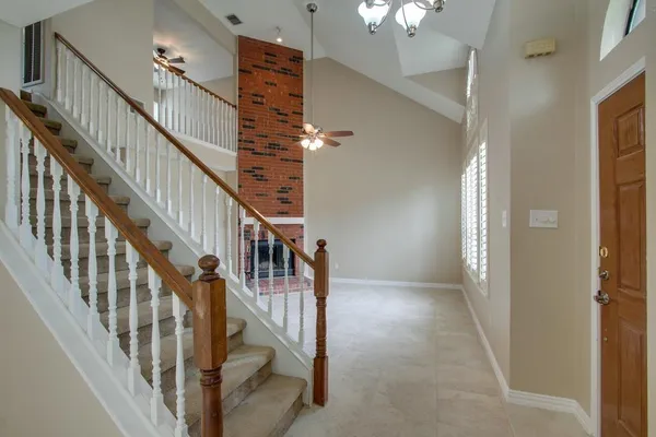 a view of staircase with lots of frames on wall and wooden floor