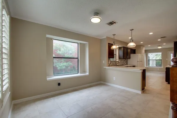 a view of an empty room with stairs and a window