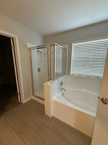 a bathroom with a bathtub a toilet and a shower