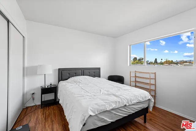 a bedroom with a bed and wooden floor