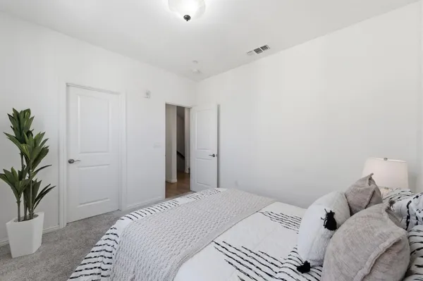 a bedroom with a bed and a potted plant