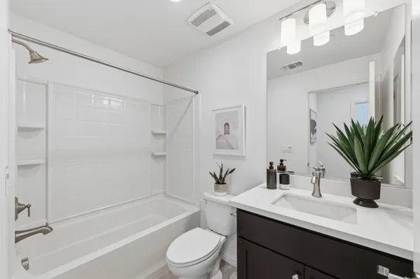 a bathroom with a granite countertop sink a toilet a mirror and shower