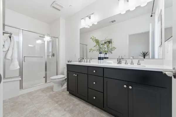 a bathroom with a sink vanity granite shower and a mirror