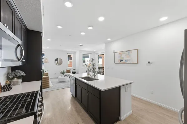 a kitchen with a sink cabinets and wooden floor