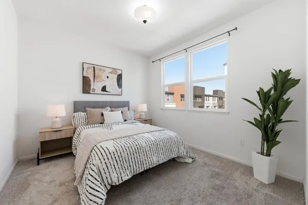 a bedroom with a large bed and potted plant