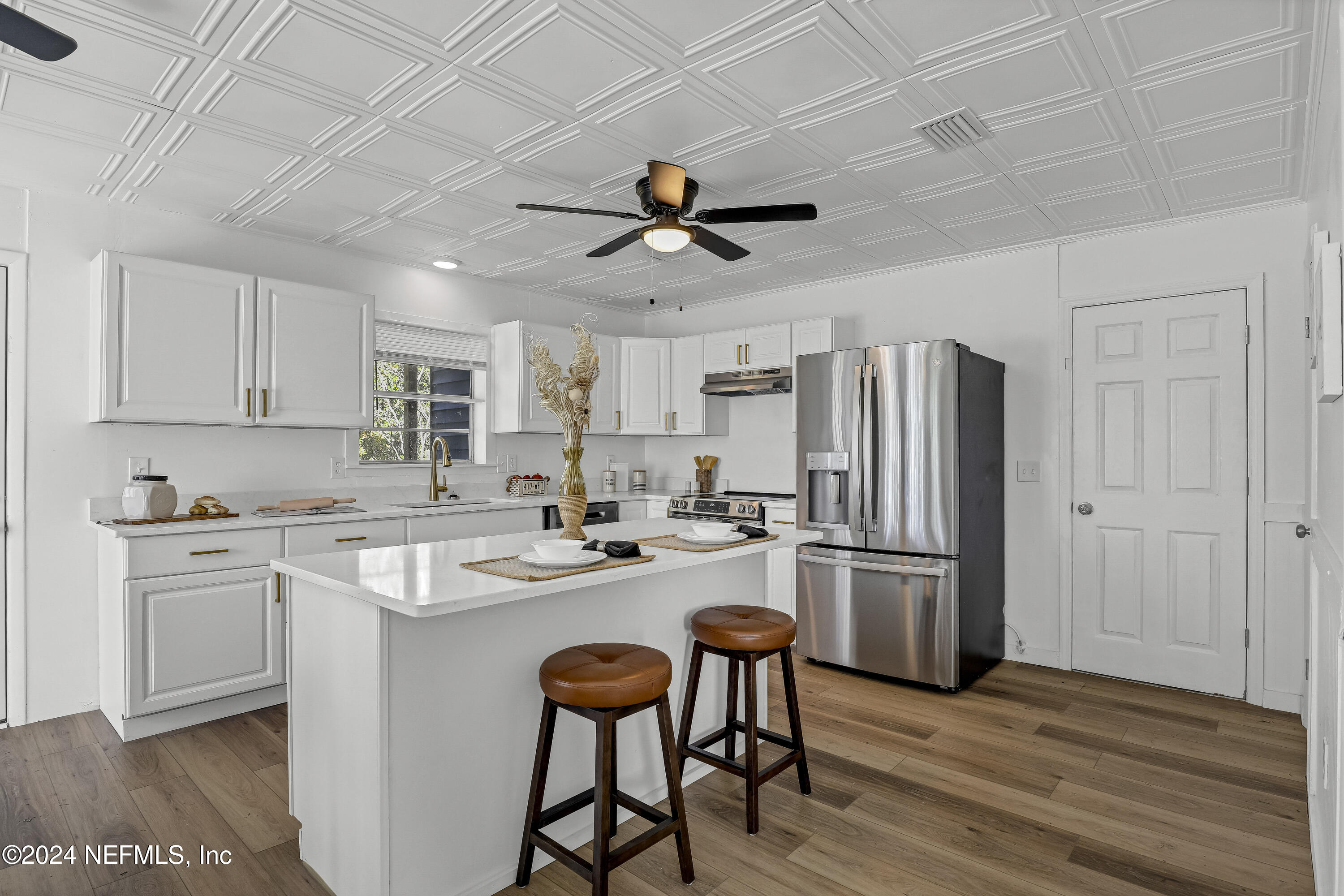 54221 Cravey Road Callahan, FL 32011 - Photo 24 of 52 a kitchen with refrigerator cabinets and wooden floor