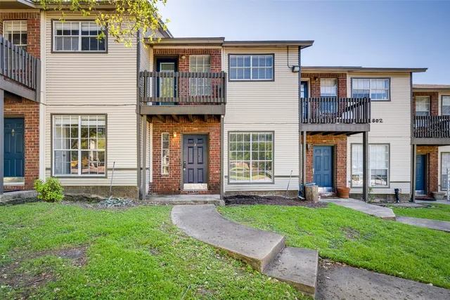 a front view of a house with a yard and glass windows