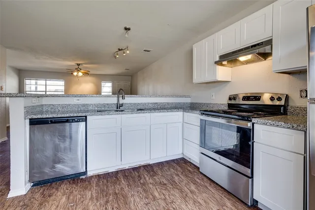 a kitchen with stainless steel appliances granite countertop a stove a sink and a microwave