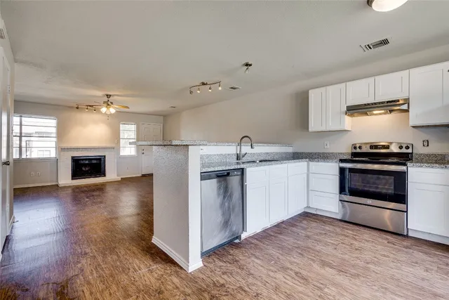 a kitchen with stainless steel appliances a stove top oven and a refrigerator