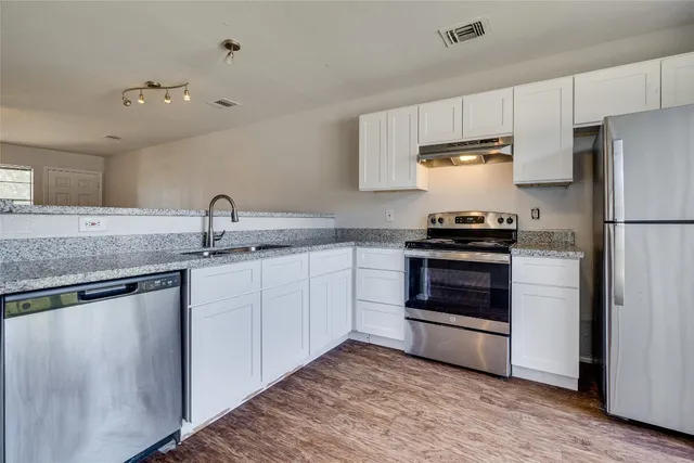 a kitchen with a sink stove and refrigerator