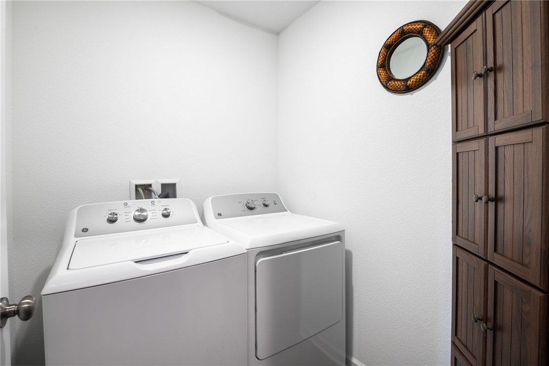 3623 East Andrea Drive Kingman, AZ 86409 - Photo 26 of 40 Laundry area featuring white walls, a washer and dryer, and dark wood storage cabinetry
