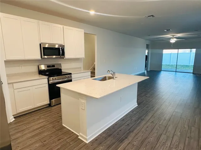 a kitchen with a sink a microwave and cabinets