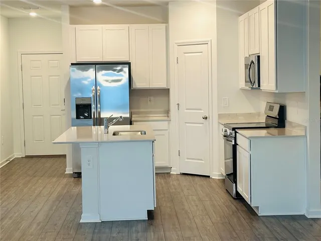a kitchen with a sink cabinets and wooden floor