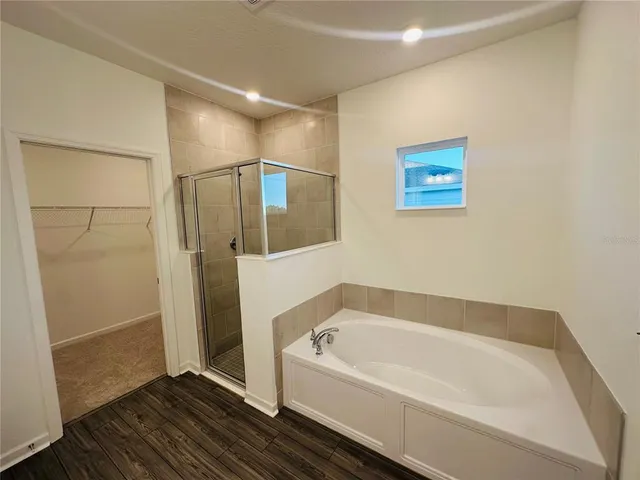 a spacious bathroom with a bathtub and shower