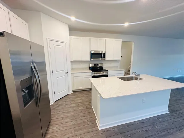 a kitchen with a sink a refrigerator and cabinets