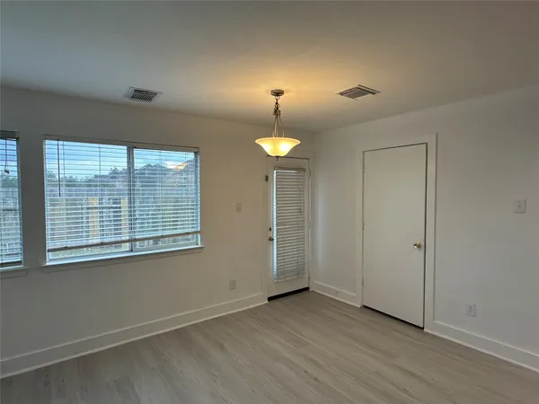 en empty room with wooden floor and window
