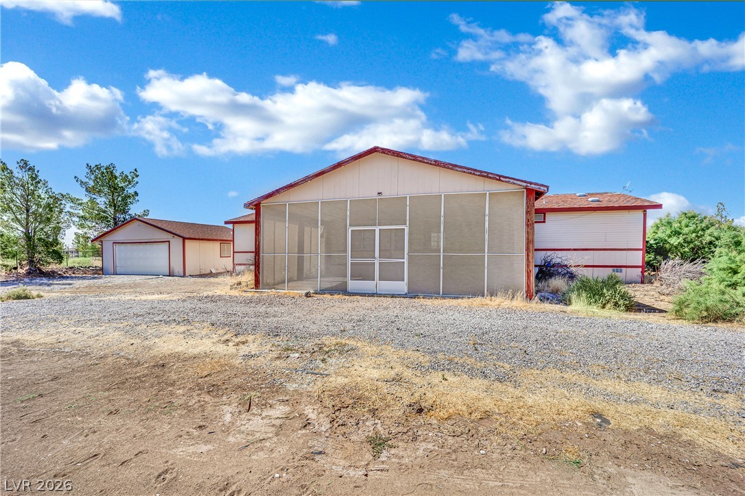 4361 Maple Road Pahrump, NV 89048 - Photo 37 of 46 A screened-in patio provides an airy retreat adjacent to a detached garage, offering versatile outdoor living.