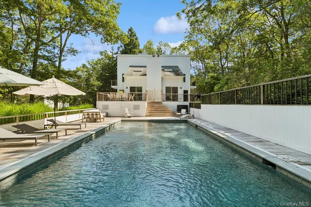 a view of a house with pool and chairs