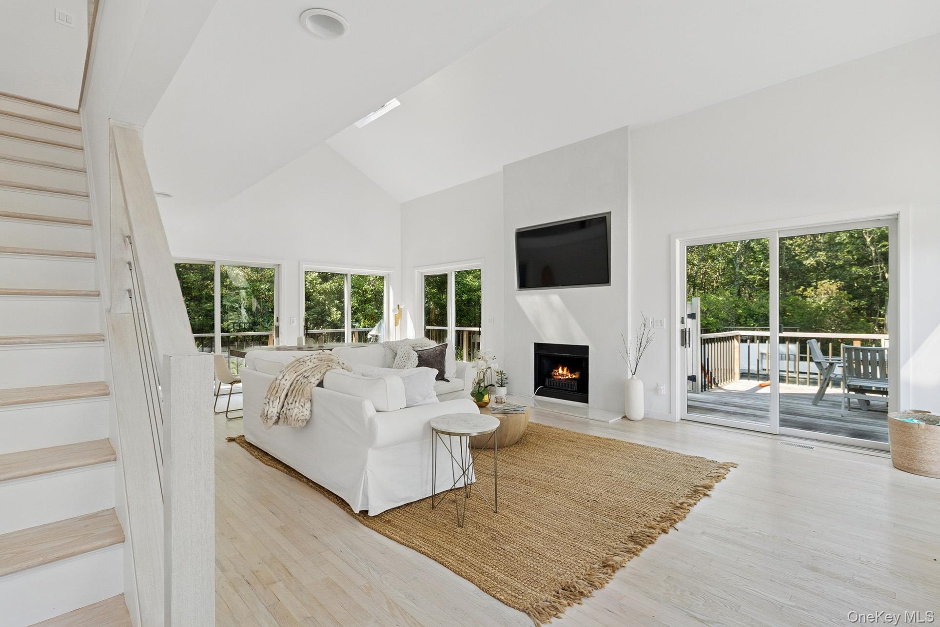 28 Ridge Road Wainscott, NY 11937 - Photo 19 of 40 a living room with furniture a fireplace and a flat screen tv