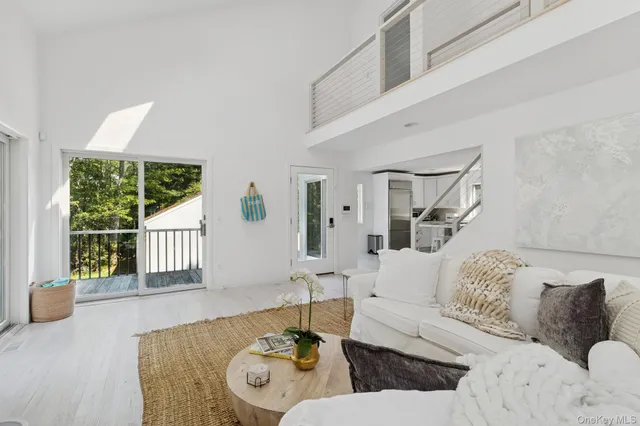 a view of a living room with large windows and wooden floor