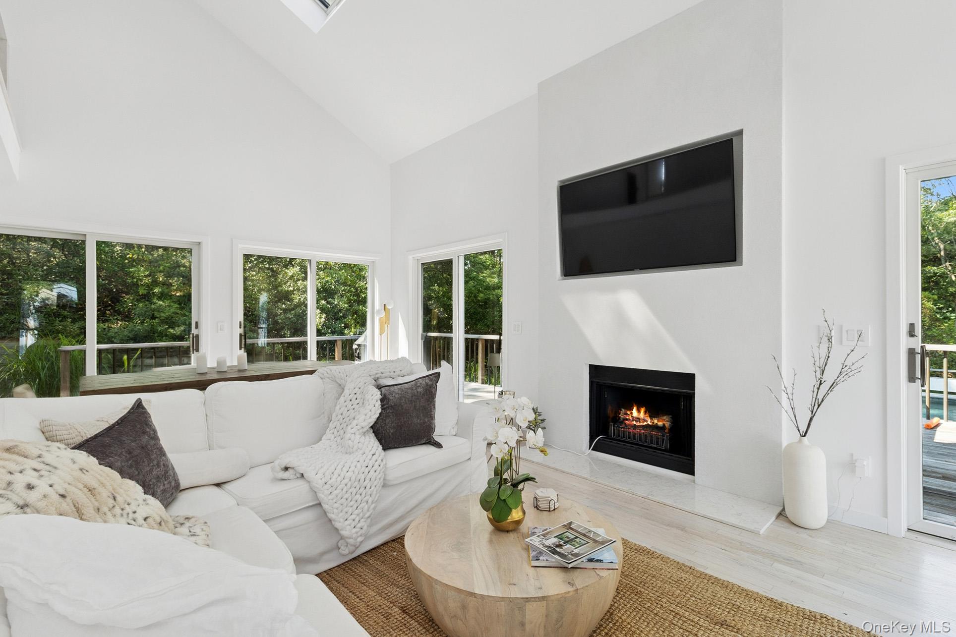 28 Ridge Road Wainscott, NY 11937 - Photo 22 of 40 a living room with furniture a fireplace and a flat screen tv