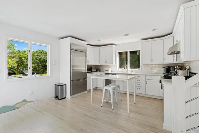 a kitchen with white cabinets and white appliances
