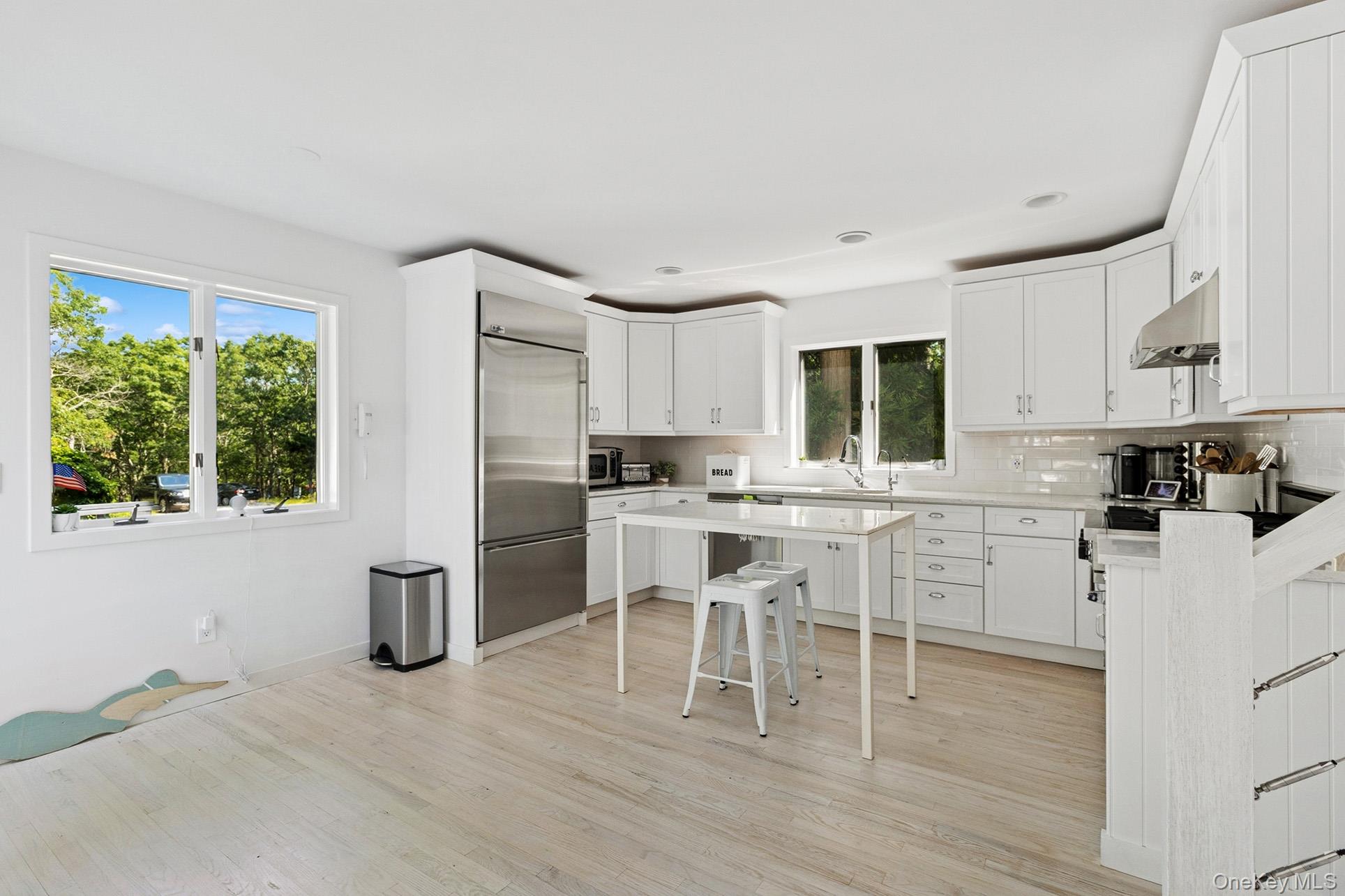 28 Ridge Road Wainscott, NY 11937 - Photo 26 of 40 a kitchen with white cabinets and stainless steel appliances
