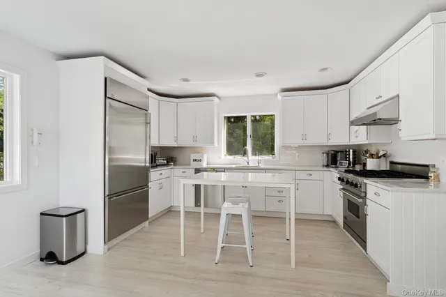 a kitchen with granite countertop white cabinets and white appliances