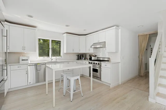 a kitchen with white cabinets and appliances