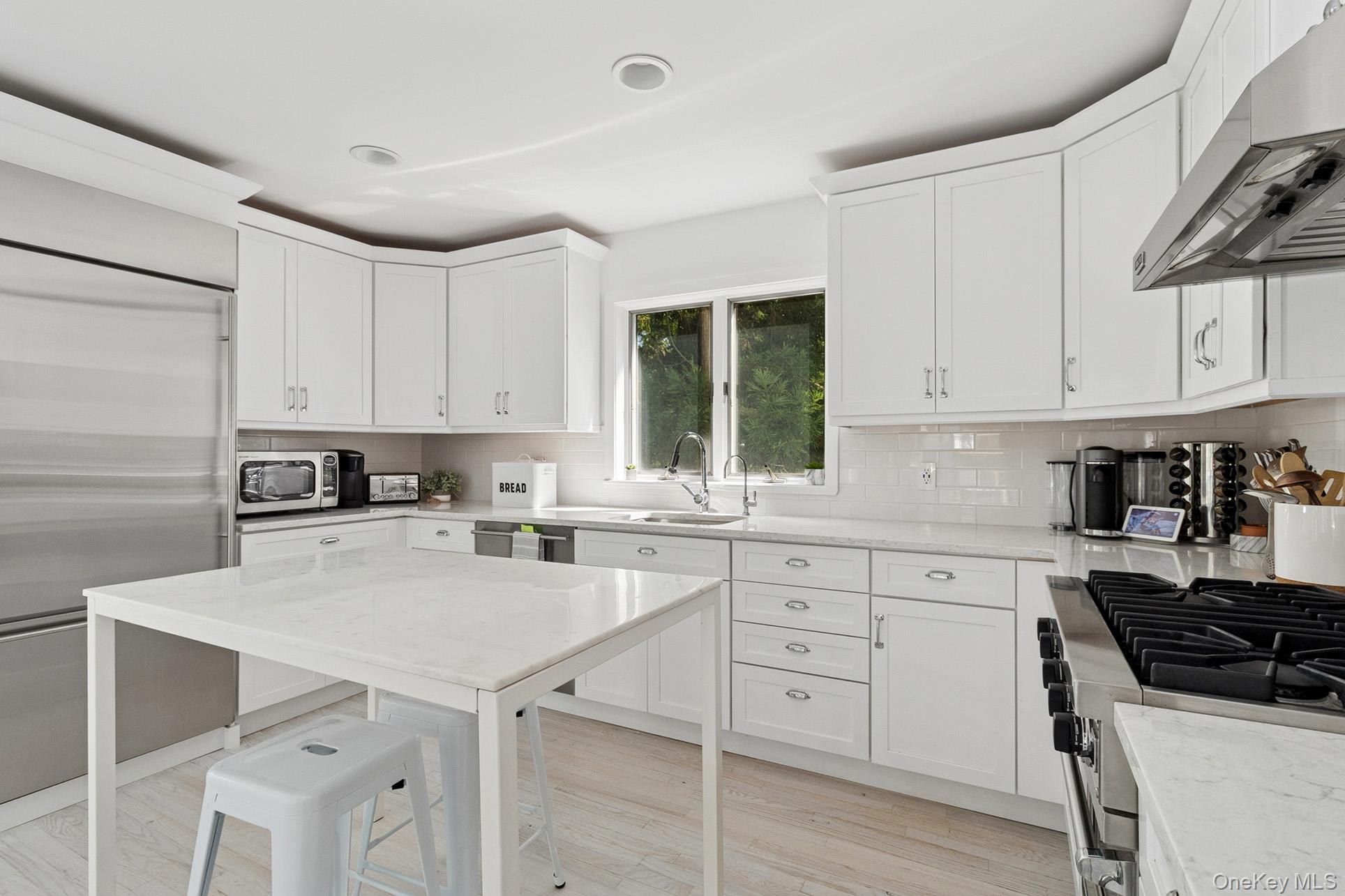28 Ridge Road Wainscott, NY 11937 - Photo 31 of 40 a kitchen with a sink a stove and cabinets