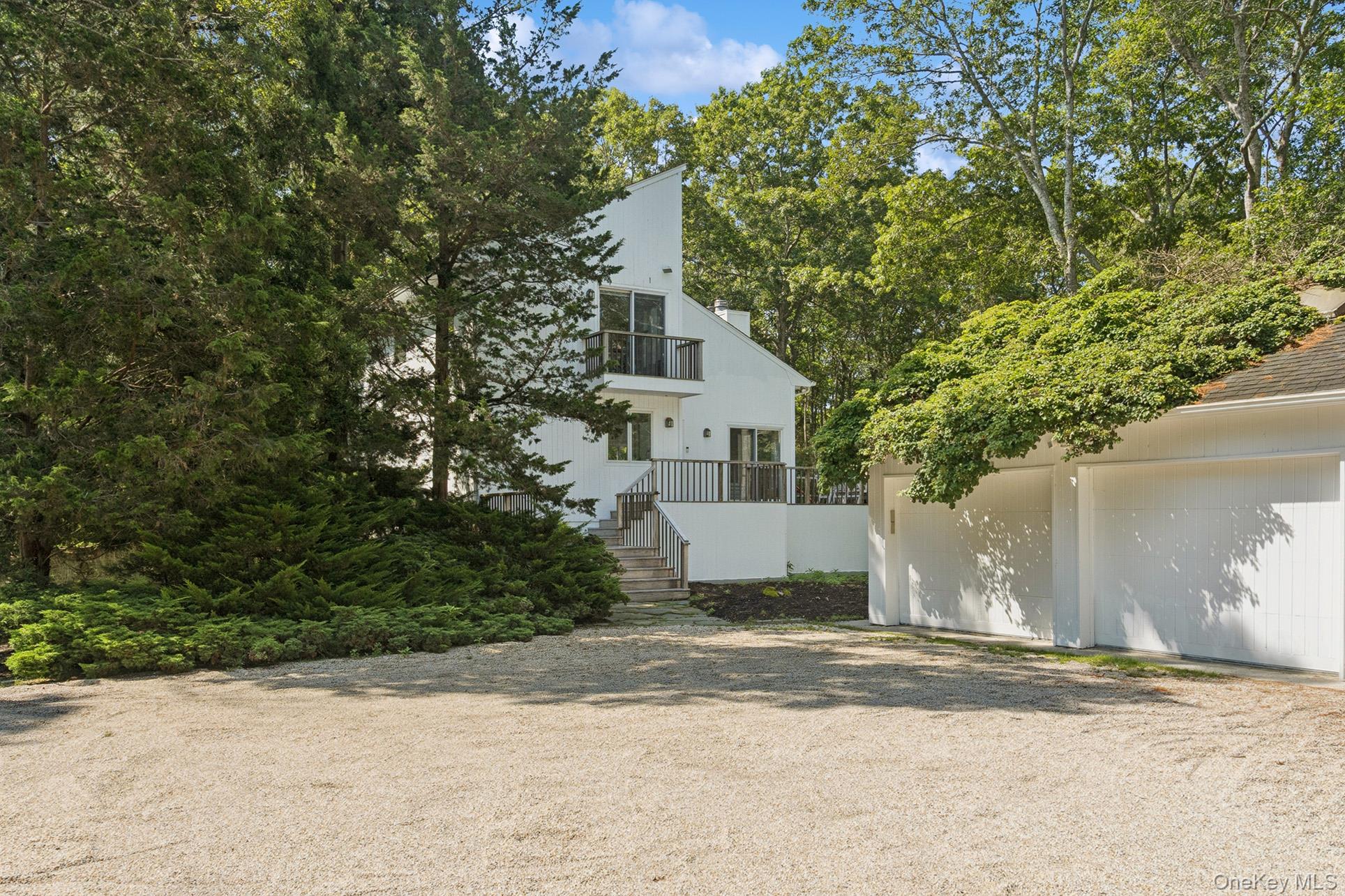 28 Ridge Road Wainscott, NY 11937 - Photo 6 of 40 a white house that has a tree in front of it