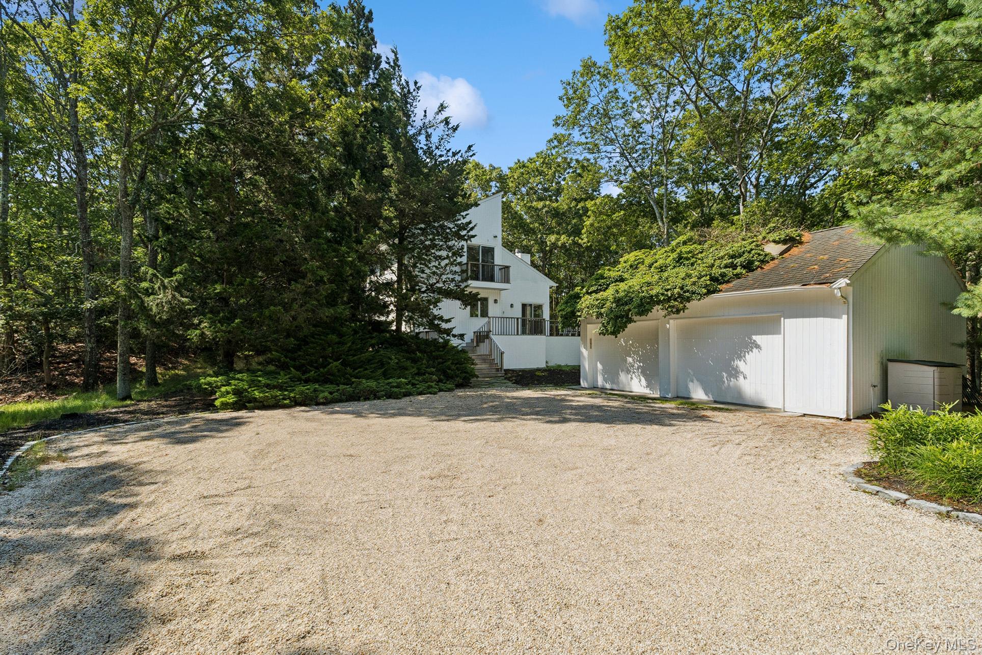 28 Ridge Road Wainscott, NY 11937 - Photo 7 of 40 a front view of a house with a yard and garage