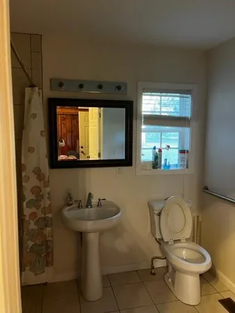 a bathroom with a toilet sink and mirror