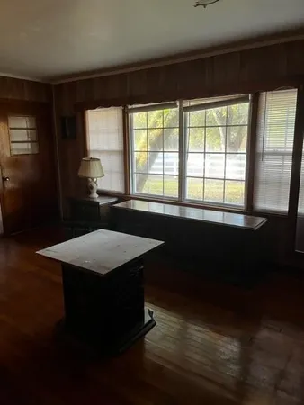 a dining room with a window wooden floor and a table