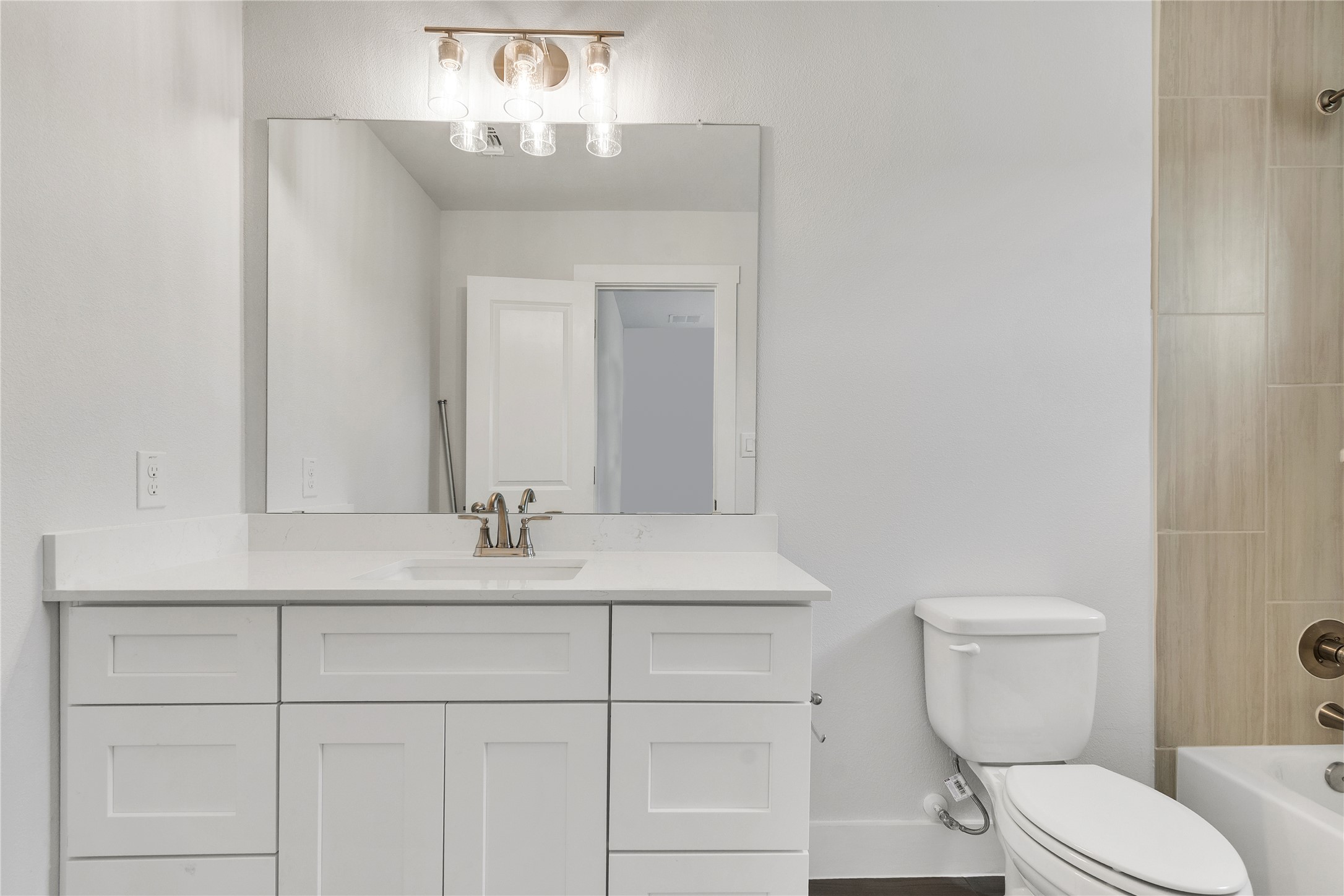 8500 Red Bottle Brush Road Lago Vista, TX 78645 - Photo 27 of 33 A spacious bathroom features a large vanity, mirror, and a sleek toilet.