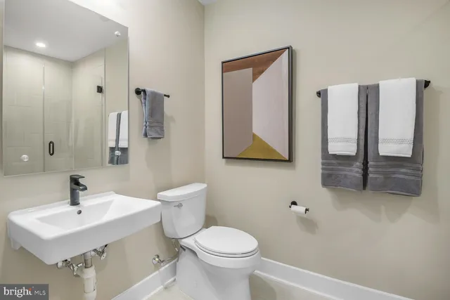 a bathroom with a toilet sink and mirror
