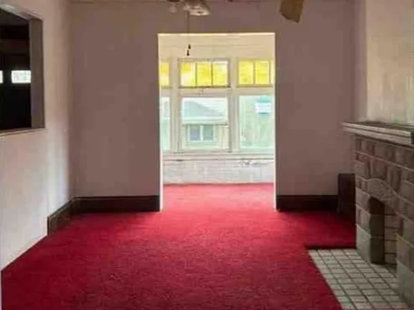an empty room with a fireplace and a window