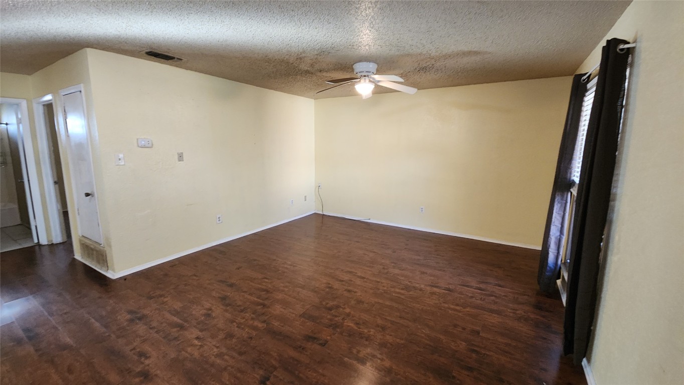 208 Vanderveer, Unit 4 Burnet, TX 78611 - Photo 3 of 13 an empty room with wooden floor and fan